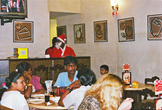 Люди обедают в Пицца Хат в Понди, штат одет как Санта Клаусы