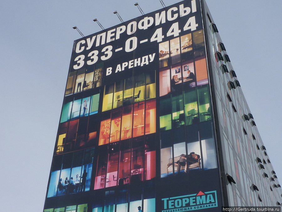 На фоне весеннего неба ярче смотрится реклама на  деловом центре Бенуа Санкт-Петербург, Россия