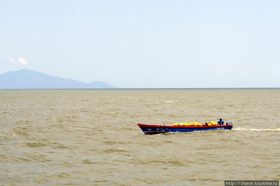 Лодка пересекает бурные воды озера Никарагуа