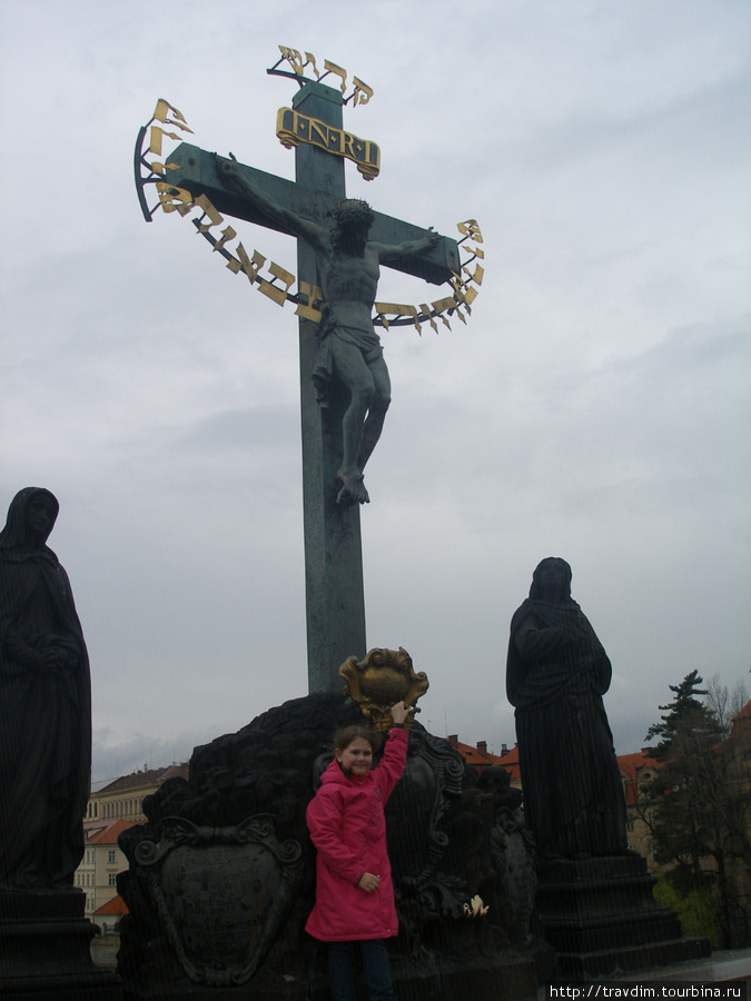 Распятый Иисус Христос на бронзовом кресте на Голгофе.Рядом с ним стоят фигуры Девы Марии и Иоана Богослова.1861г. Прага, Чехия