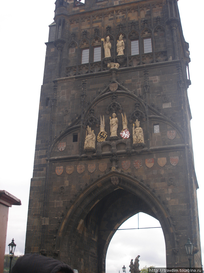 Мостовая башня ,которая соединяет Карлов мост и Кржижовницкую площадь.На башне статуи Св.Вита,чешских правителей и гербы разных земель. Прага, Чехия
