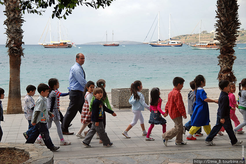 Дети из детсада прогуливаются вдоль моря, и хором повторяют стихи своему воспитателю. Бодрум, Турция