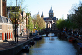 Помню, что одно из самых ярких впечатлений в первой поездке в Амстердам (тогда я была проездом) было у меня от квартала Красных фонарей. Огромная негритянка оголила перед нами — девчонками грудь и показала язык. Бр-рр. Вспоминаю, до сих пор содрогаюсь. Естественно, мы с мужем, как и многие наши соотечественники, прилетев вечером в Амстердам, первым делом отправились туда, где в свете красно-фиолетовых неоновых огней путаны демонстрируют себя. На сей раз ночное шоу за стеклом удивило обилием симпатичных славянских лиц, силиконовых грудей и красивых фигур. 
Фотографировать представительниц древнейшей профессии в квартале Красных фонарей запрещено. Но каналы, лебедей, архитектуру никто снимать не воспрещает. С утра здесь тихо и целомудренно.