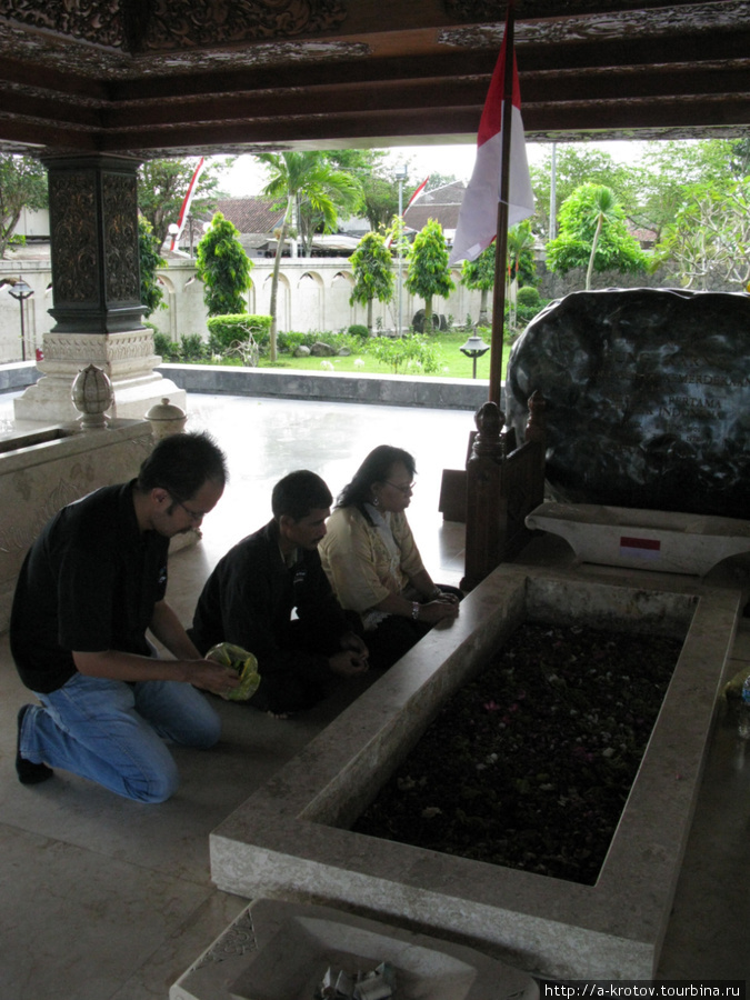 Местные жители кладут лепестки цветов на могилу Блитар, Индонезия