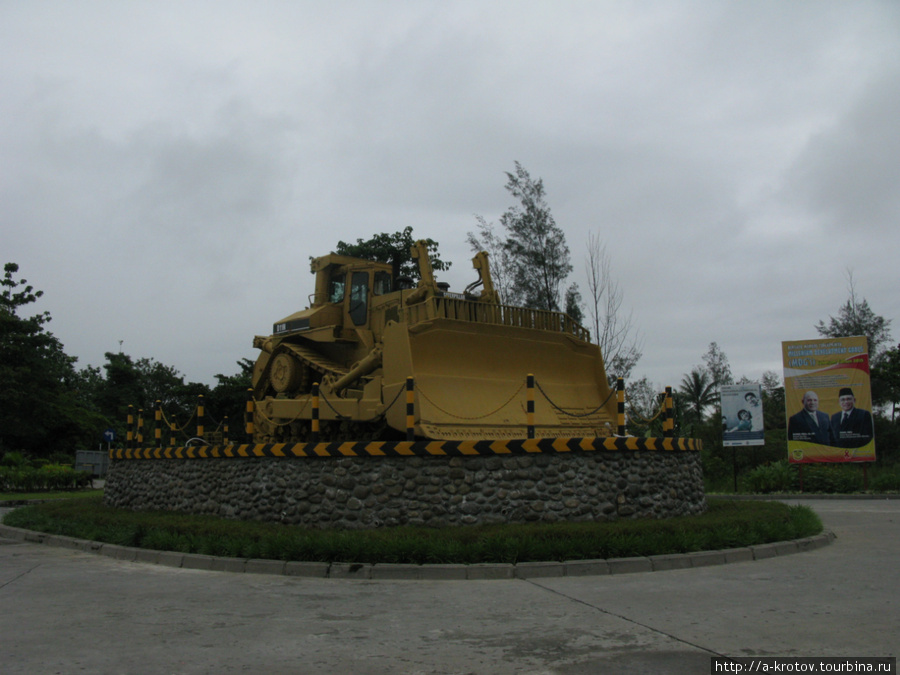 Памятник бульдозеру перед аэропортом Тимика, Индонезия