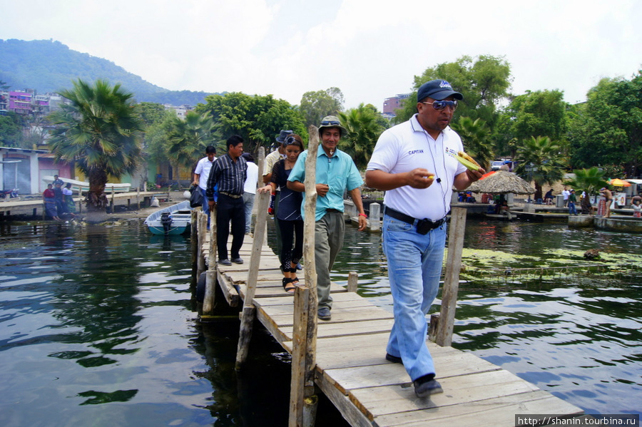 Пассажиры идут по пристани Сантьяго Атитлан, Гватемала