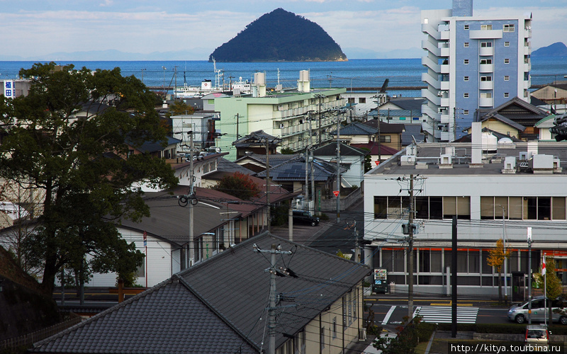 Вид на город и море с холма, на котором стоит замок Усуки, Япония
