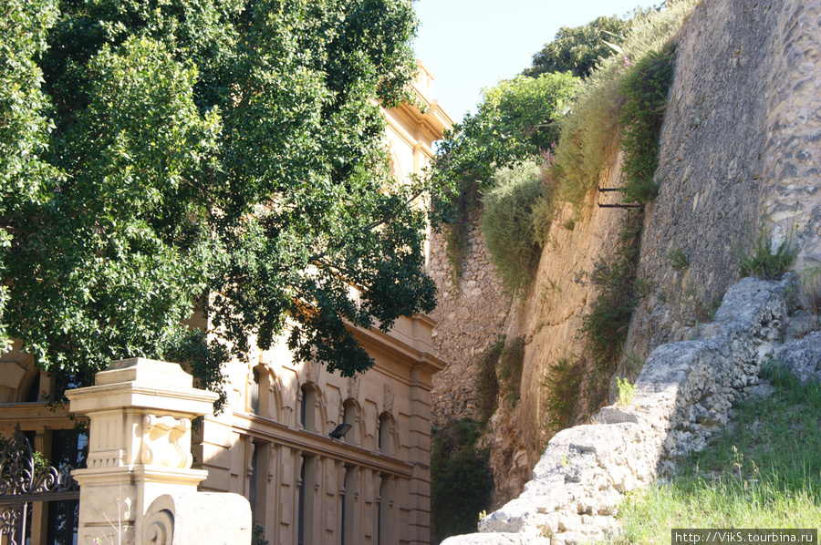 Вплотную к крепости построены современные здания. Высота стен впечатляет. Кальяри, Италия