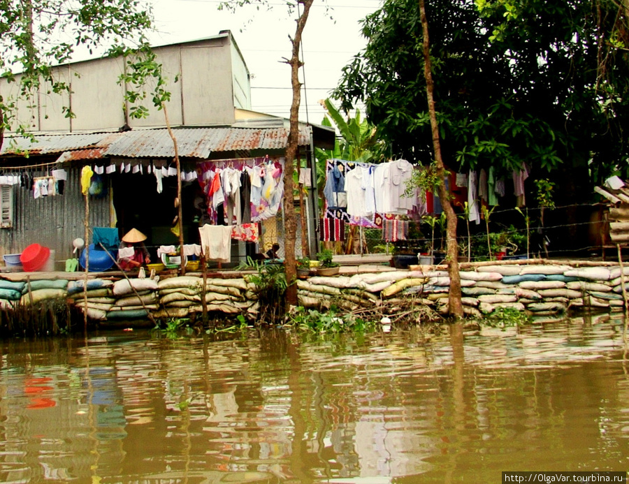 Некоторые защищают свои дома со стороны реки мешками в случае наводнения Кантхо, Вьетнам