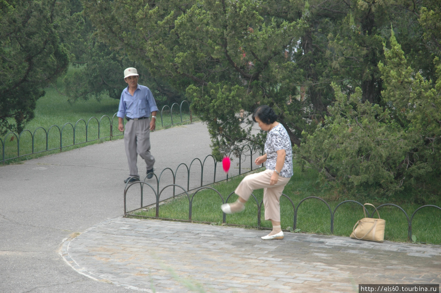 эта бабушка набивает ногами какой-то мячик с перьями.. Пекин, Китай