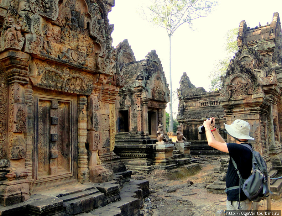 На барельефе сценка, которую пытается запечатлеть турист: Демон с тысячей голов и рук пытается вырвать с корнем гору Кайлаш, обиталище Шивы Провинция Сиемреап, Камбоджа