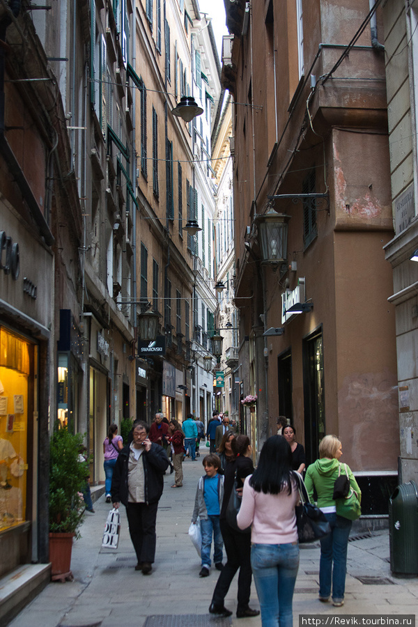 Стены улиц  наваливаются на прохожих Генуя, Италия