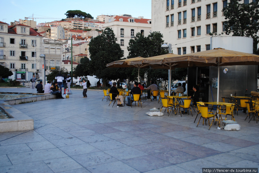 С обеих сторон от фонтана находятся два кафе. Расстояние между ними метров 30. В одном сидят только азиаты. Лиссабон, Португалия