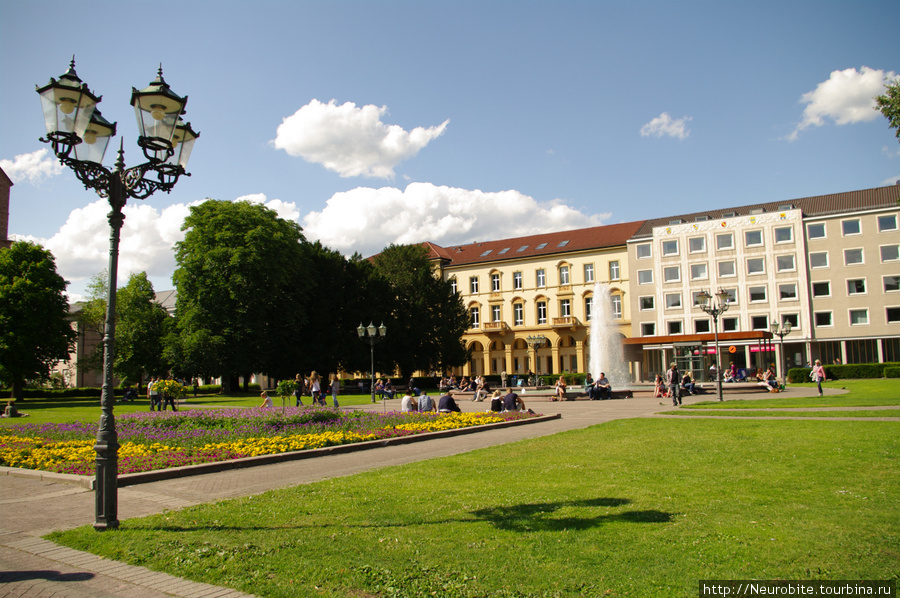 Велосипедом с фотоаппаратом через плечо по центру Карлсруэ Карлсруэ, Германия