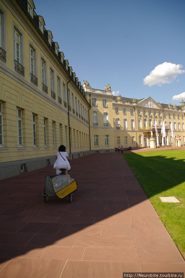 Велосипедом с фотоаппаратом через плечо по центру Карлсруэ Карлсруэ, Германия