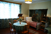 Одна небольшая комнатка, которую занимала семья Гагариных. Две кровати, диван, стол и радиола, на которой можно проигрывать пластинки. Вещи тех, 50-х годов.