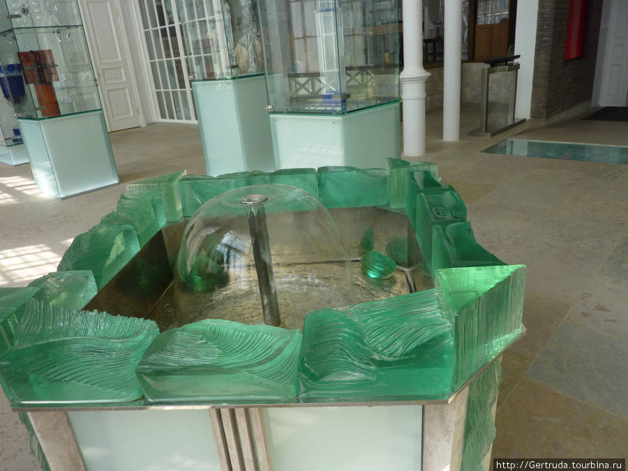 Небольшой фонтанчик в обрамлении зеленого стекла. Санкт-Петербург, Россия