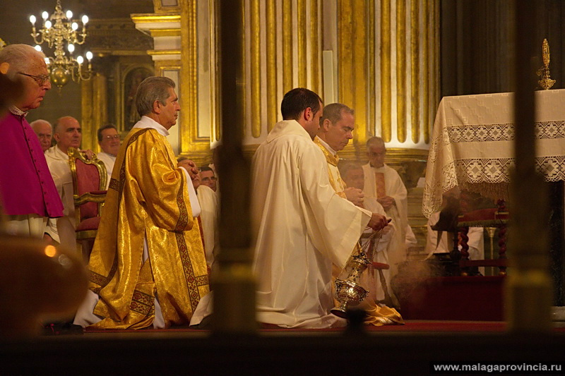 Торжественная молитва. Архиепископ стоит на коленях позади стола, закрывающего его от публики Малага, Испания