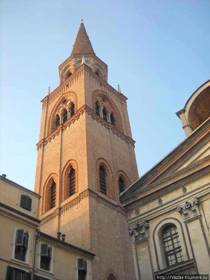 Церковная колокольня; справа виден фрагмент фасада, никак не сочетающийся с колокольней Мантуя, Италия