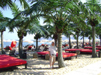 Вполне приличный пляж с мелкозернистым песочком, пальмами, зонтиками и шезлонгами