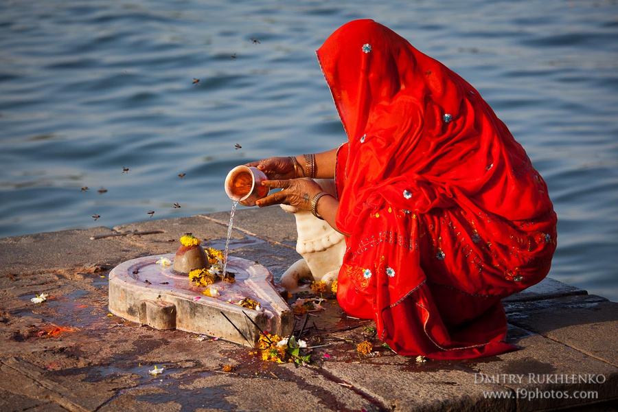 Утром женщины по очереди совершают подношения Шиве: приносят цветочки (бархатцы).поливают лингам чем-то сладким (думаю, медом), что очень радует ос. А водой из священной реки тоже поликают, конечно. Махешвар, Индия